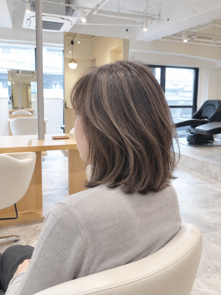 白髪ぼかしの伸び方を自然になじませたミディアムボブとSOY-KUFU店内