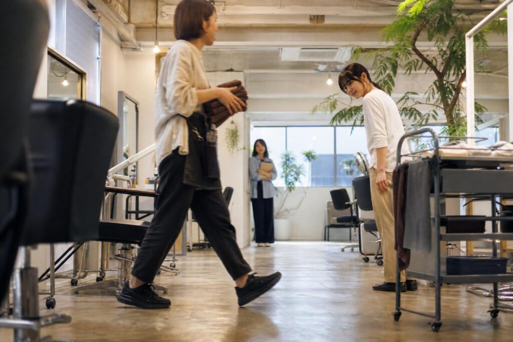営業中のサロンでスタッフの動きを観察する見学者